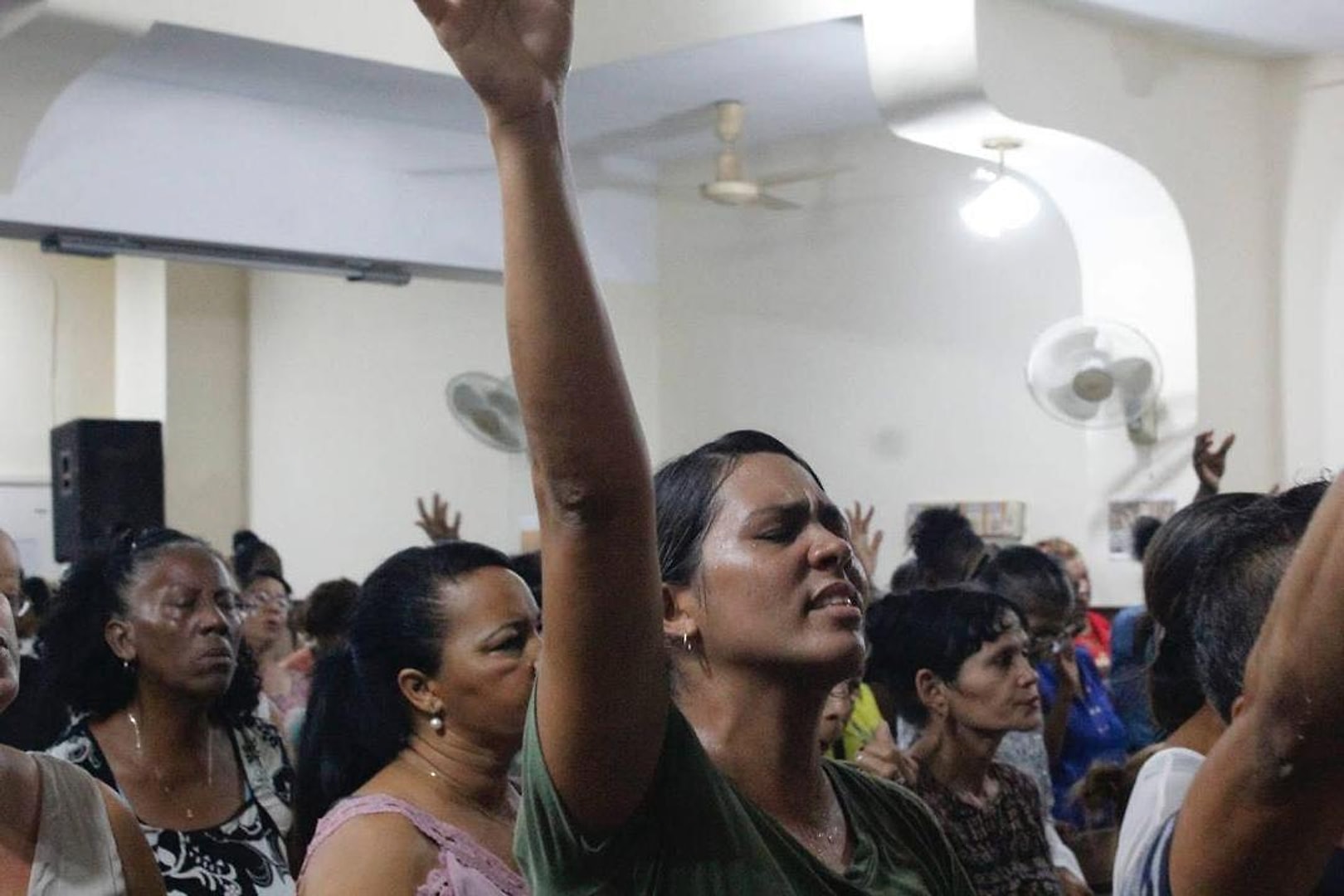 Congregación adorando con las manos levantadas durante el culto